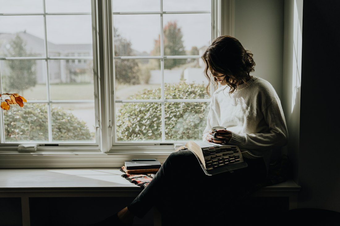 A person reading by a window
